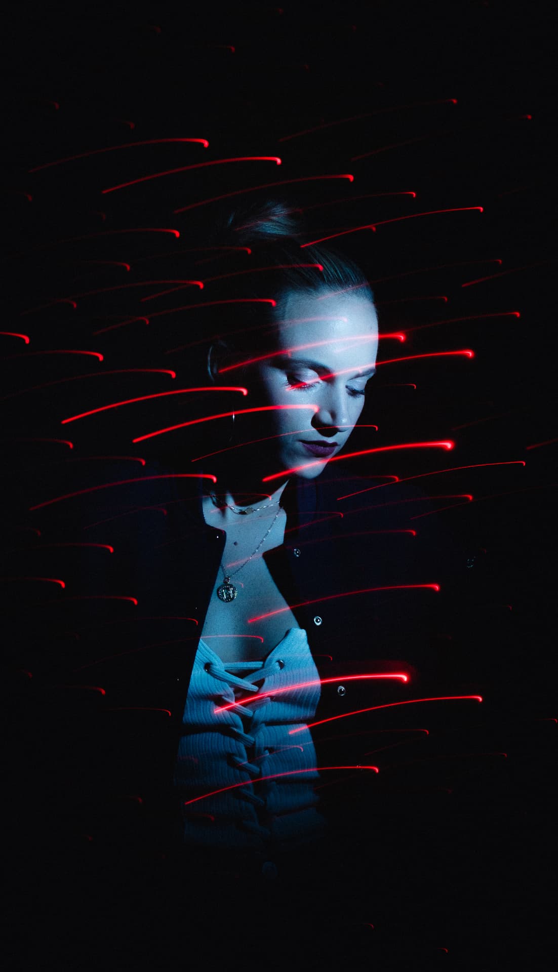 Blue-lit profile portrait surrounded by red light trails by Dan Almasy