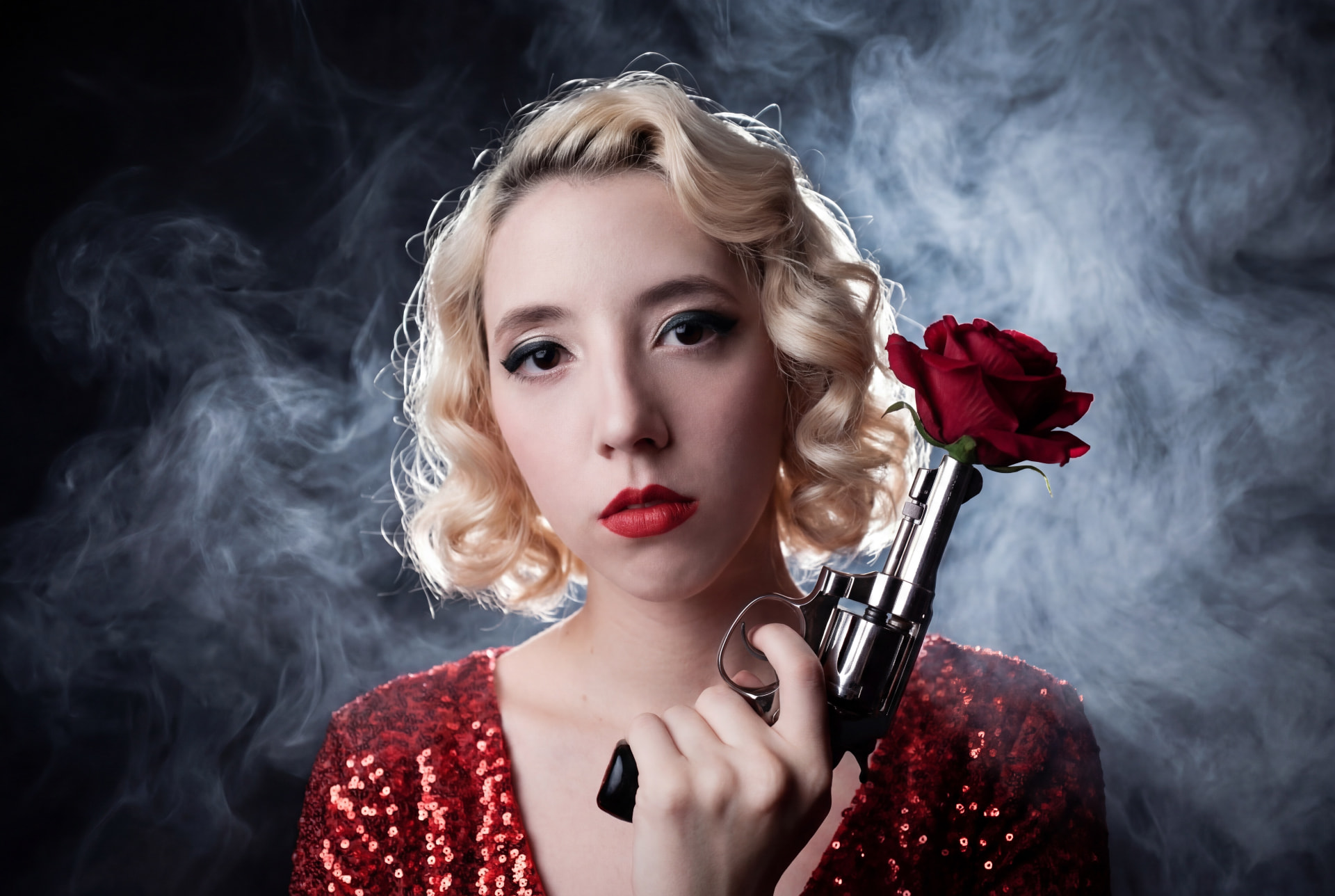 Film-noir portrait in red sequins with revolver and rose by Dan Almasy
