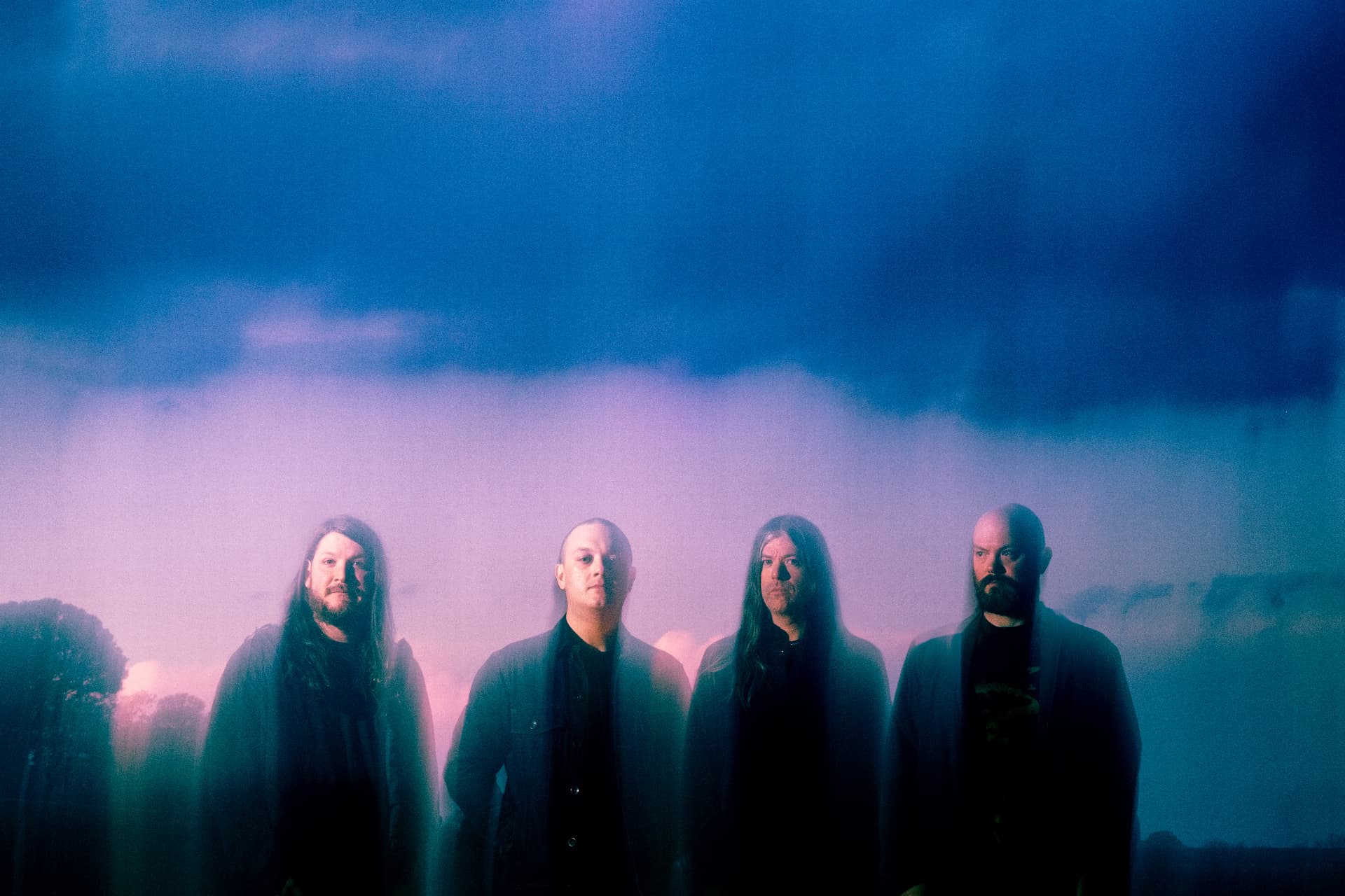 Four-piece band at dusk under a purple and blue sky by Dan Almasy
