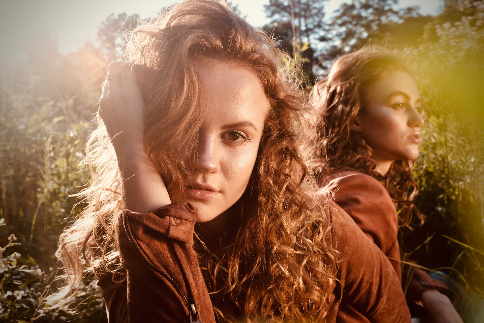 Sunlit portrait of two models in suede jackets by Dan Almasy