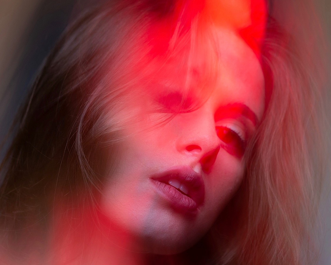 Close-up portrait bathed in red light by Dan Almasy