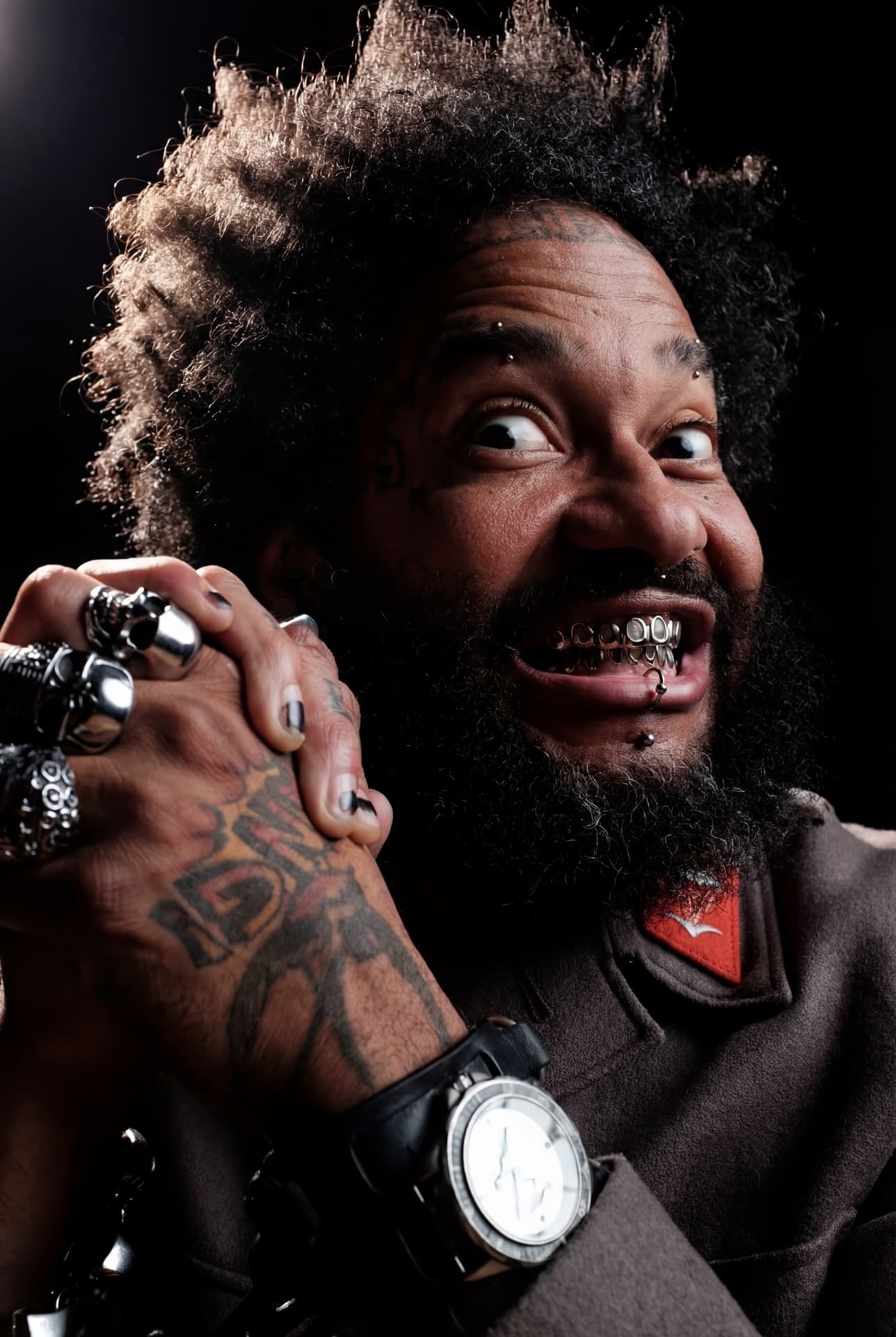 Dramatic portrait of a tattooed man with silver grills by Dan Almasy