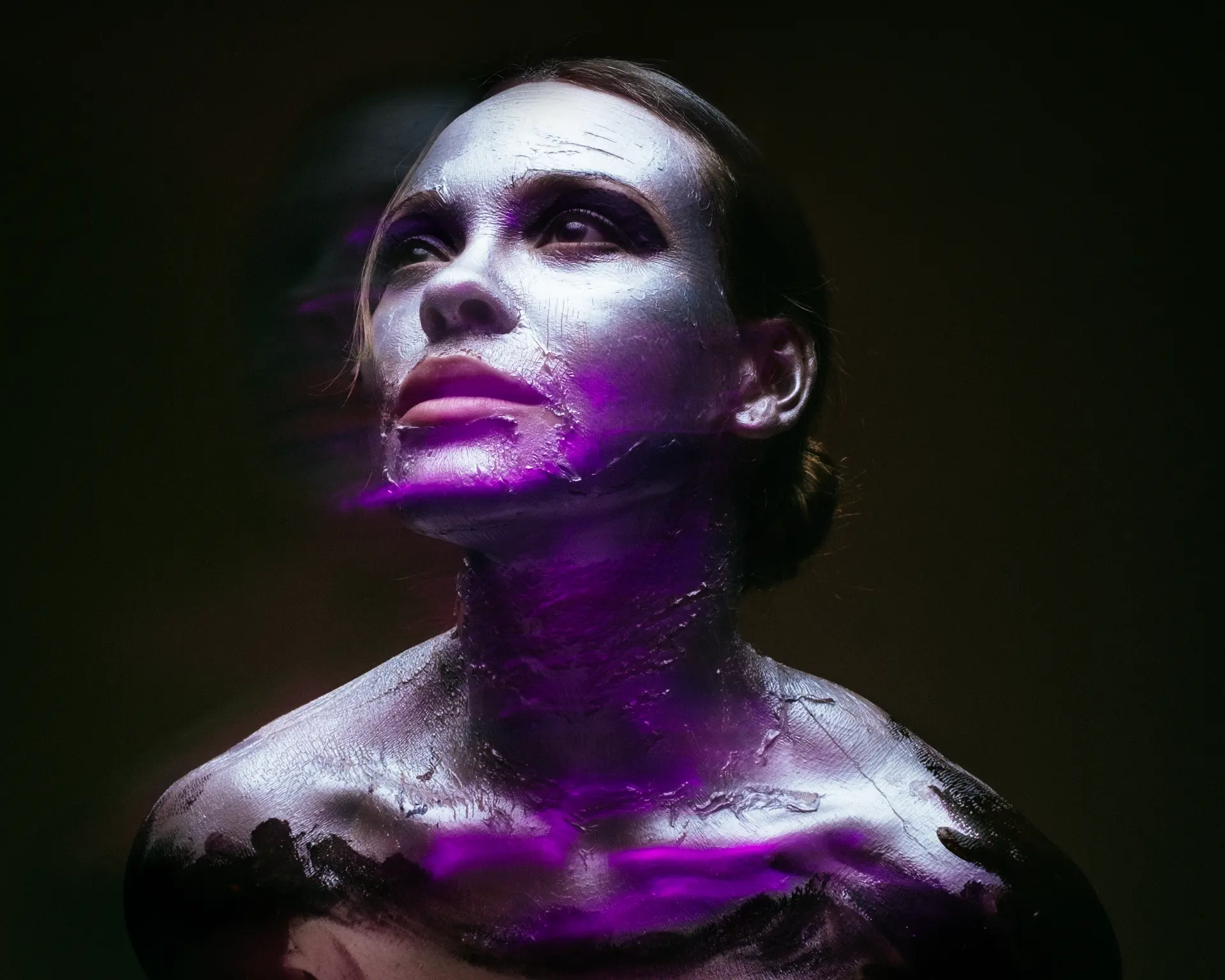 Silver-painted figure under magenta light by Dan Almasy