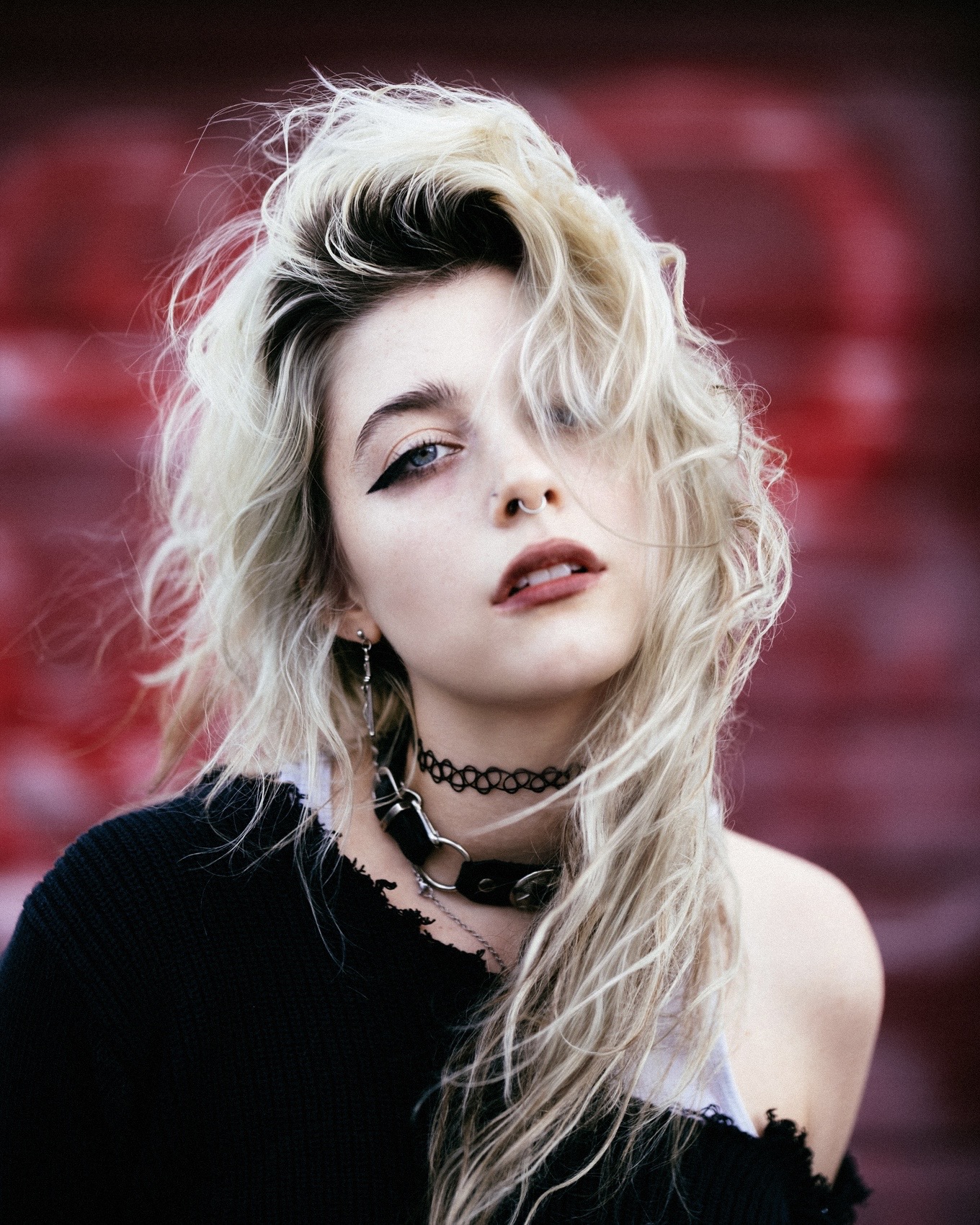 Blonde portrait in a black knit top against a crimson backdrop by Dan Almasy