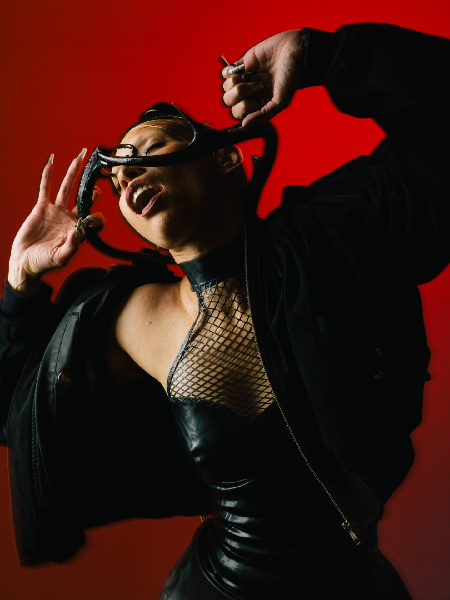 Leather-clad figure against a crimson backdrop by Dan Almasy